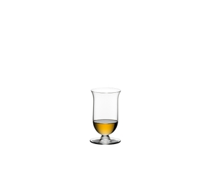 2 glasses of RIEDEL Vinum Single Malt Whisky and a carafe filled with whisky on a stone wall.