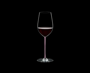 RIEDEL Fatto A Mano Riesling/Zinfandel Pink R.Q. filled with a drink on a black background