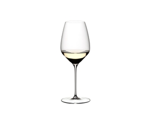 Two RIEDEL Veloce Riesling glasses one filled with white wine and an unfilled glass on a white background.
