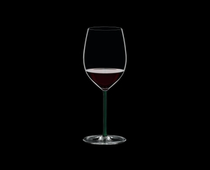 RIEDEL Fatto A Mano R.Q. Cabernet/Merlot Green filled with a drink on a black background