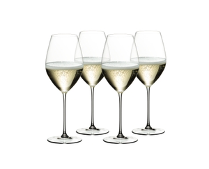 Four filled RIEDEL Veritas Champagne Wine glasses stand slightly offset next to each other