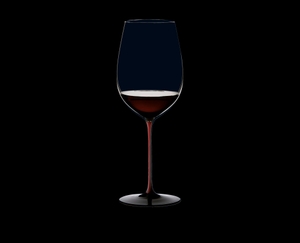 RIEDEL Black Series Collector's Edition Bordeaux Grand Cru gefüllt mit einem Getränk auf schwarzem Hintergrund