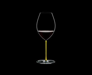 RIEDEL Fatto A Mano Syrah Yellow filled with a drink on a black background