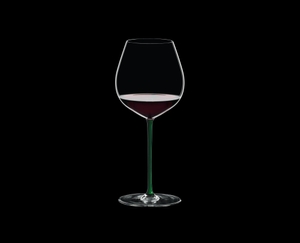 RIEDEL Fatto A Mano Pinot Noir Green filled with a drink on a black background