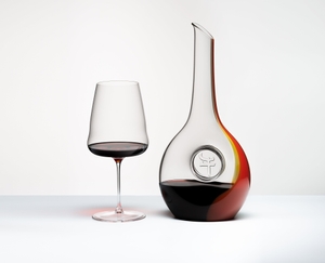 Red wine filled RIEDEL RIEDEL Chinese Zodiac Ox Decanter with red and gold stripe down one side and an embedded zodiac symbol for the Ox in the center