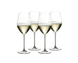 Four RIEDEL Veritas Champagne Wine Glasses with champagne tand side by side or slightly behind each other on a white background.