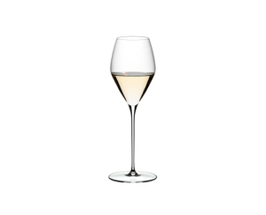 Two RIEDEL Veloce Sauvignon Blanc glasses one filled with white wine and one unfilled on a white background.
