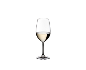A woman holds a RIEDEL Vinum Riesling Grand Cru/Zinfandel glass under her nose to smell and look at the white wine.