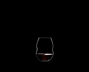 RIEDEL Swirl Red Wine filled with a drink on a black background