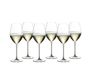 Six RIEDEL Veritas Restaurant Champagne Wine Glasses filled with champagne tand side by side or slightly behind each other on a white background.