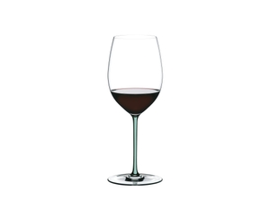 A RIEDEL Fatto A Mano Cabernet with a mint colored stem and filled with red wine.