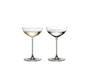 Two RIEDEL Veritas Coupe/Cocktail glasses side by side. The glass on the left side is filled with champagne, the other one is filled with a clear drink.