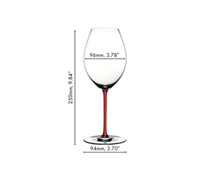 A red wine filled RIEDEL Fatto A Mano Syrah red glass with a red stem on a white background.