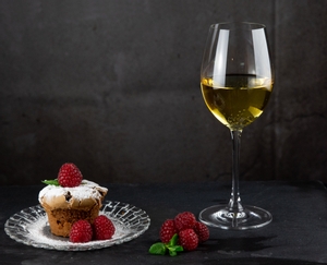 2 RIEDEL Vinum Sauvignon Blanc/Dessertwine glasses standing side by side on white background. The glass on the left is filled with a Sauvignon Blanc, the other one is filled with a dessertwine.