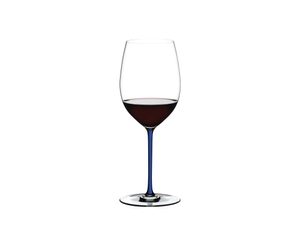 A RIEDEL Fatto A Mano Cabernet/Merlot in dark blue filled with red wine on a transparent background. 