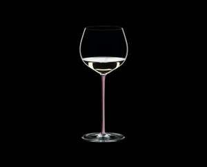 RIEDEL Fatto A Mano Oaked Chardonnay Pink filled with a drink on a black background