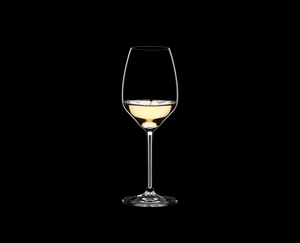 RIEDEL Extreme Riesling filled with a drink on a black background
