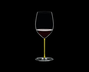 RIEDEL Fatto A Mano Cabernet/Merlot Yellow filled with a drink on a black background