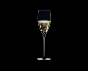 RIEDEL Sommeliers Black Tie Jahrgangschampagner Glas gefüllt mit einem Getränk auf weißem Hintergrund