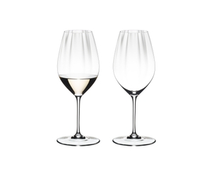 Two RIEDEL Performance Riesling glasses side by side. The glass on the left side is filled with white wine, the other one is empty.