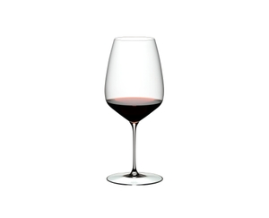 A RIEDEL Veloce Cabernet / Merlot glass filled with red wine on a white background.