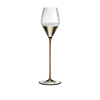 RIEDEL High Performance Champagne Glass Gold filled with a drink on a white background