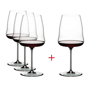 Three plus one RIEDEL Winewings Syrah glasses filled with red wine on a white background.