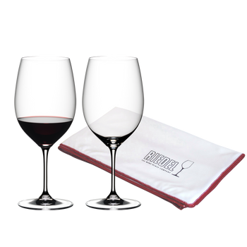 One red wine filled and one unfilled RIEDEL Vinum Cabernet Sauvignon/Merlot (Bordeaux) glass and a RIEDEL Microfiber Polishing Cloth on white background