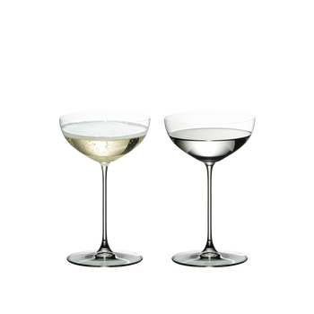 Two RIEDEL Veritas Coupe/Cocktail glasses side by side. The glass on the left side is filled with champagne, the other one is filled with a clear drink.