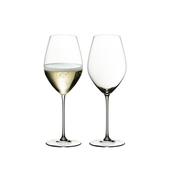 Two glasses RIEDEL Veritas Champagne Wine on a white background. The glass on the left side is filled with champagne, the other one is unfilled.