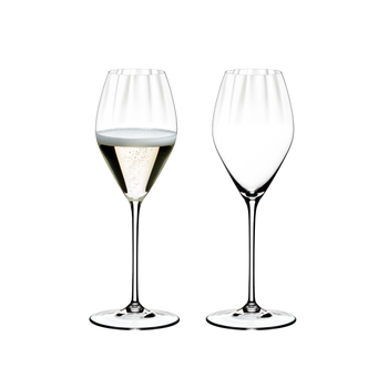 Two RIEDEL Performance Champagne Glasses side by side. The glass on the left side is filled with champagne, the other one is empty.