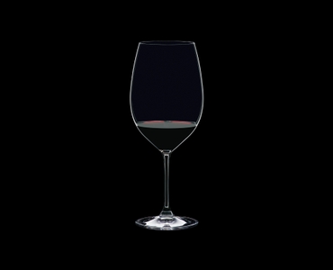 RIEDEL Restaurant Bordeaux Grand Cru gefüllt mit einem Getränk auf schwarzem Hintergrund