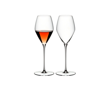 Two RIEDEL Veloce Rose glasses one filled with rose wine and an unfilled glass on a white background.