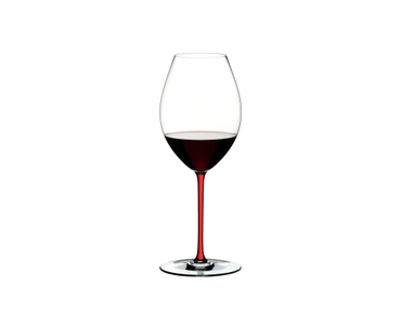 A RIEDEL Fatto A Mano Syrah glass in red filled with red wine on a transparent background. 