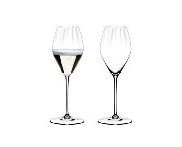 Two RIEDEL Performance Champagne Glasses side by side. The glass on the left side is filled with champagne, the other one is empty.