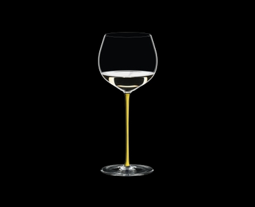 RIEDEL Fatto A Mano Oaked Chardonnay Yellow filled with a drink on a black background