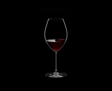 RIEDEL Veritas Old World Syrah filled with a drink on a black background