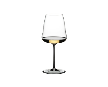 A RIEDEL Winewings Chardonnay glass filled with white wine on a white background.