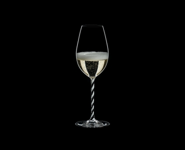 RIEDEL Fatto A Mano Champagne Wine Glass Black & White R.Q. filled with a drink on a black background