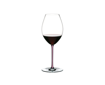 A RIEDEL Fatto A Mano Syrah with a mauve stem and filled with red wine on a white background.