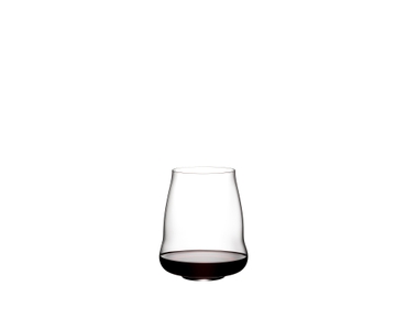 A blond woman smells her wine by holding a SL RIEDEL Stemless Wings Pinot Noir / Nebbiolo glass filled with red wine.