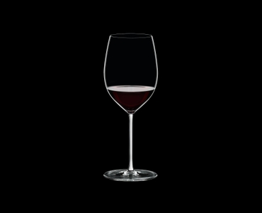 RIEDEL Fatto A Mano Cabernet/Merlot White R.Q. filled with a drink on a black background