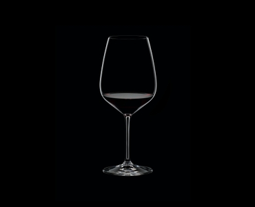 RIEDEL Extreme Cabernet filled with a drink on a black background