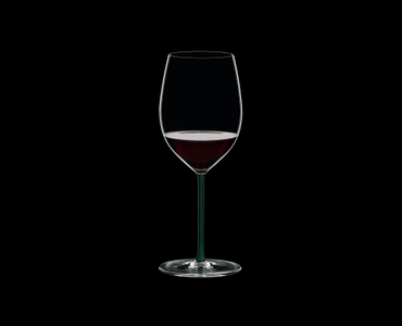 RIEDEL Fatto A Mano Cabernet/Merlot Green filled with a drink on a black background