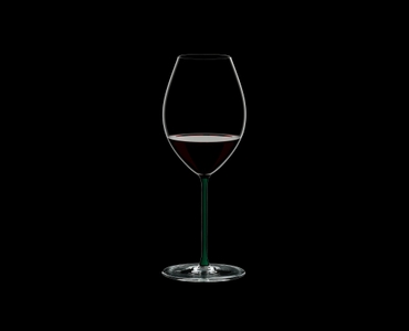 RIEDEL Fatto A Mano Syrah Green R.Q. filled with a drink on a black background