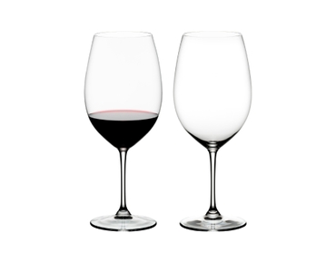 Two RIEDEL Vinum Bordeaux Grand Cru glasses on white background. The one on the left side is filled with red wine, the other one is empty.
