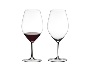 Two RIEDEL Wine Friendly Magnum glasses side by side against a white background. The glass on the left side is filled with red wine, the glass on the right side is empty.