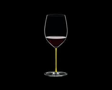RIEDEL Fatto A Mano R.Q. Cabernet/Merlot Yellow filled with a drink on a black background