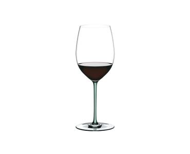 A RIEDEL Fatto A Mano Cabernet with a mint colored stem and filled with red wine.
