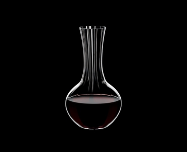 RIEDEL Decanter Performance filled with a drink on a black background